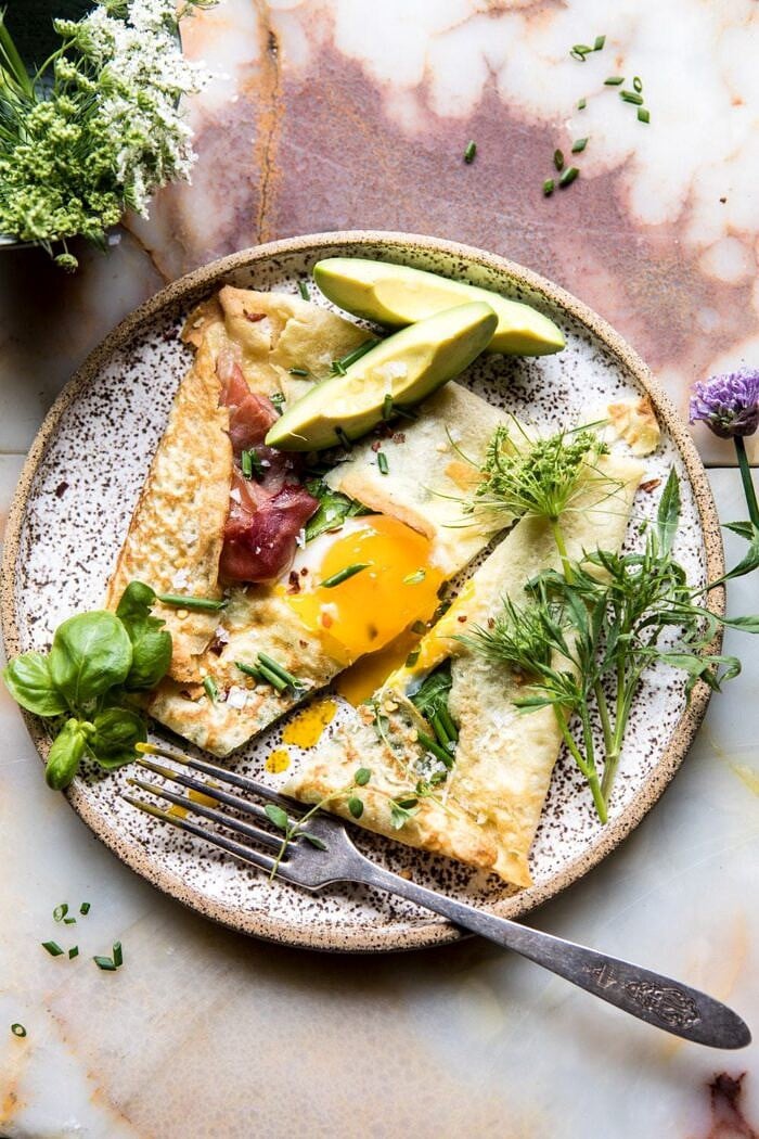 Baked Egg Crepes with Spring Herbs and Avocado | halfbakedharvest.com #breakfast #brunch #easyrecipe overhead photo of cut into Baked Egg Crepes with Spring Herbs and Avocado