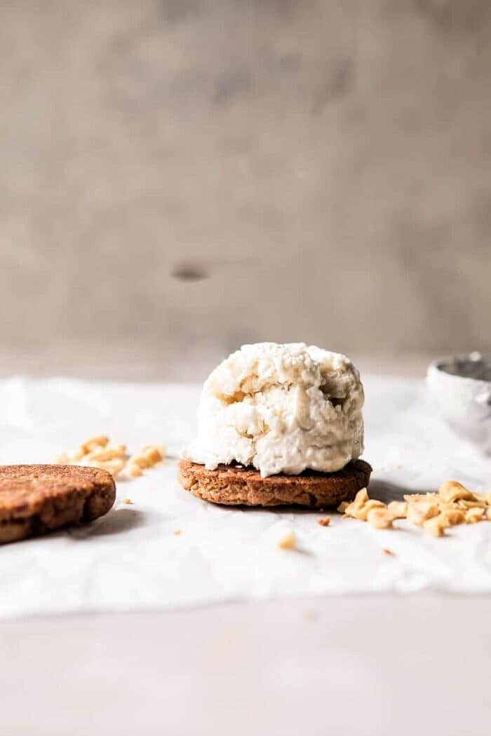 Chocolate Dipped Peanut Cookie Ice Cream Sandwiches | halfbakedharvest.com #icecream #chocolate #peanutbutter #summer front on photo of Peanut Cookie with ice cream scoop
