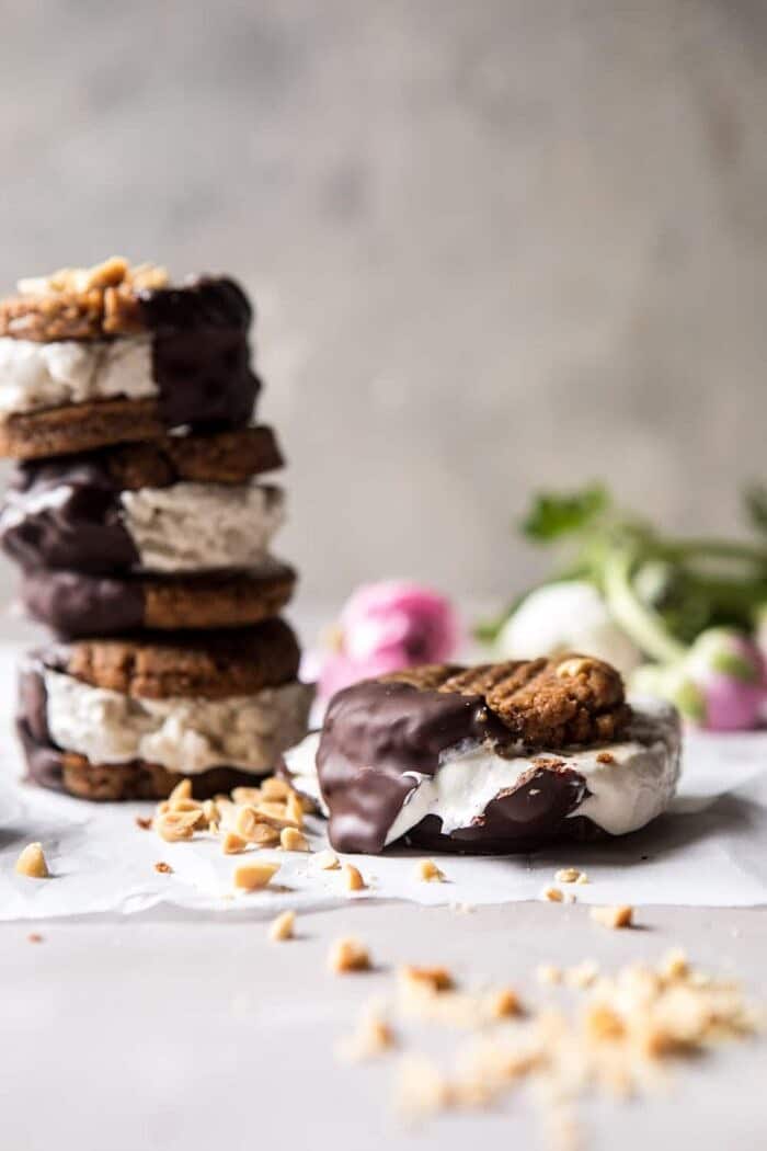 Chocolate Dipped Peanut Cookie Ice Cream Sandwiches | halfbakedharvest.com #icecream #chocolate #peanutbutter #summer front on photo of smashed Chocolate Dipped Peanut Cookie Ice Cream Sandwich with ice cream melting
