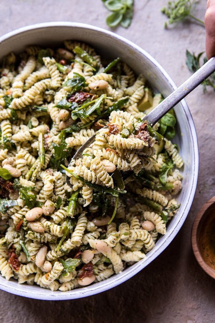 Sun-Dried Tomato, White Bean, and Goat Cheese Pasta Salad | halfbakedharvest.com #quick #healthy #easyrecipes #salad overhead photo of Sun-Dried Tomato, White Bean, and Goat Cheese Pasta Salad with spoonful of pasta being removed
