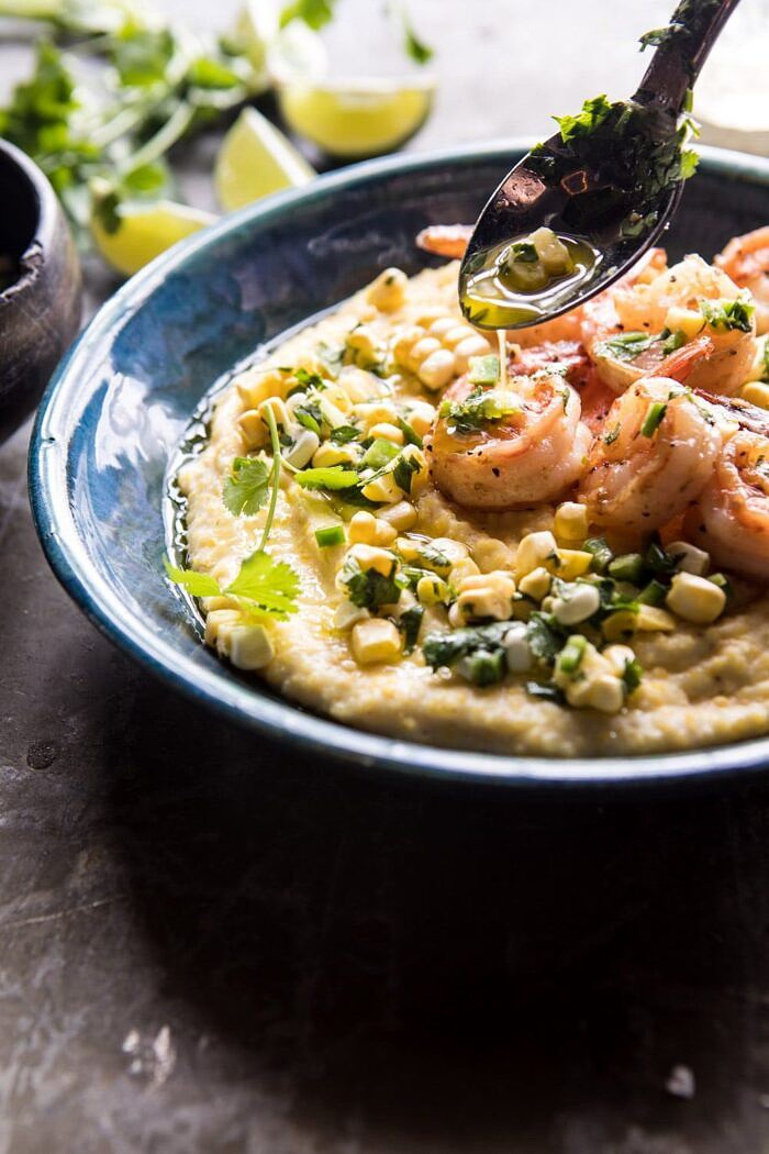 Sweet Corn Chimichurri Butter Shrimp with Polenta | halfbakedharvest.com #summer #shrimp #easyrecipes drizzling side angle photo of Sweet Corn Chimichurri Butter Shrimp with Polenta