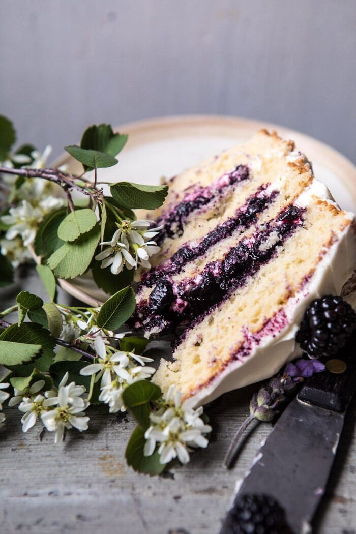 Blackberry Lavender Naked Cake with White Chocolate Buttercream | halfbakedharvest.com #summerrecipes #layercake #blueberries close up photo of Blackberry Lavender Naked Cake slice