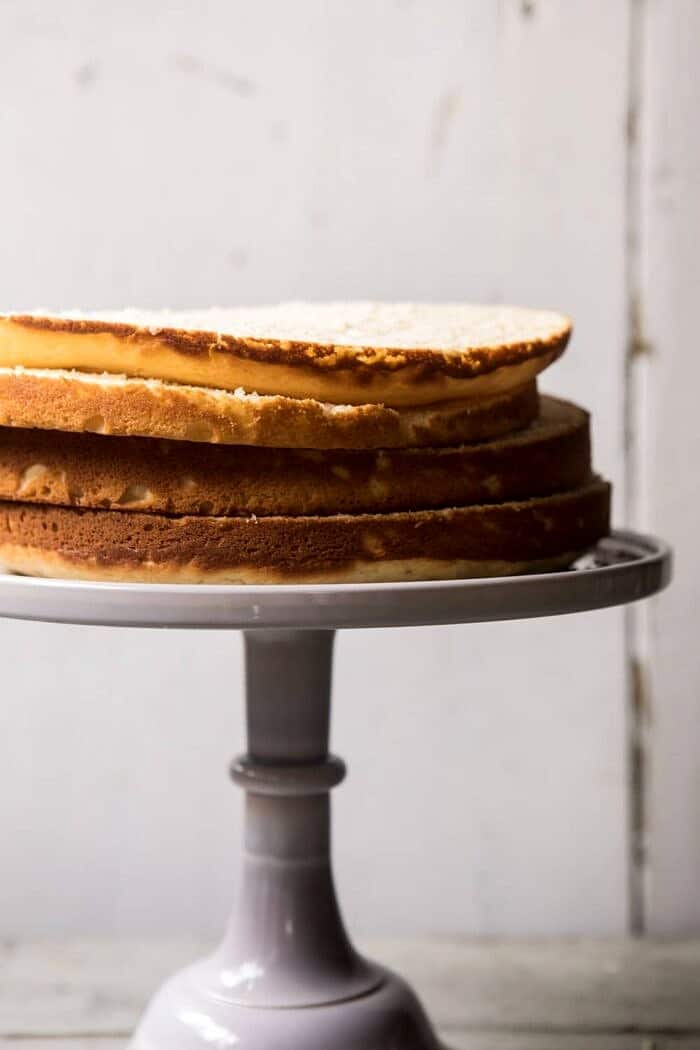 Blackberry Lavender Naked Cake with White Chocolate Buttercream | halfbakedharvest.com #summerrecipes #layercake #blueberries front on photo of vanilla cake layers