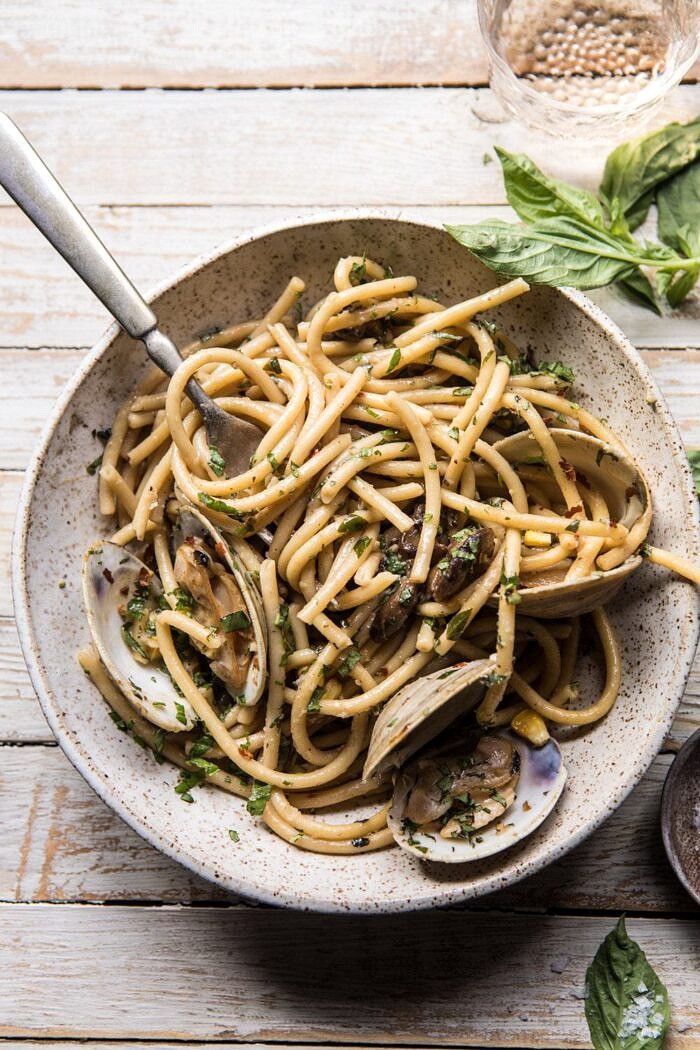 Buttery Mushroom and Clam Pasta | halfbakedharvest.com #pasta #easyrecipe #summerrecipes overhead photo Buttery Mushroom and Clam Pasta with fork and half eaten bowl