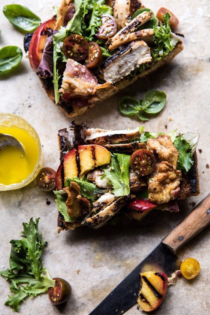 Open Faced Rosemary Chicken, Peach, and Bacon Sandwich | halfbakedharvest.com #summerrecipe #easyrecipes #peach #chicken #healthy overhead photo of Open Faced Rosemary Chicken, Peach, and Bacon Sandwich with knife and piece missing