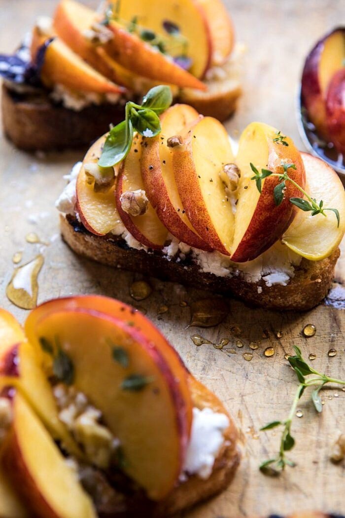 Thyme, Honey, Peach, and Goat Cheese Crostini | halfbakedharvest.com #peaches #summerrecipes #appetizers #easy close up angled photo of Thyme, Honey, Peach, and Goat Cheese Crostini