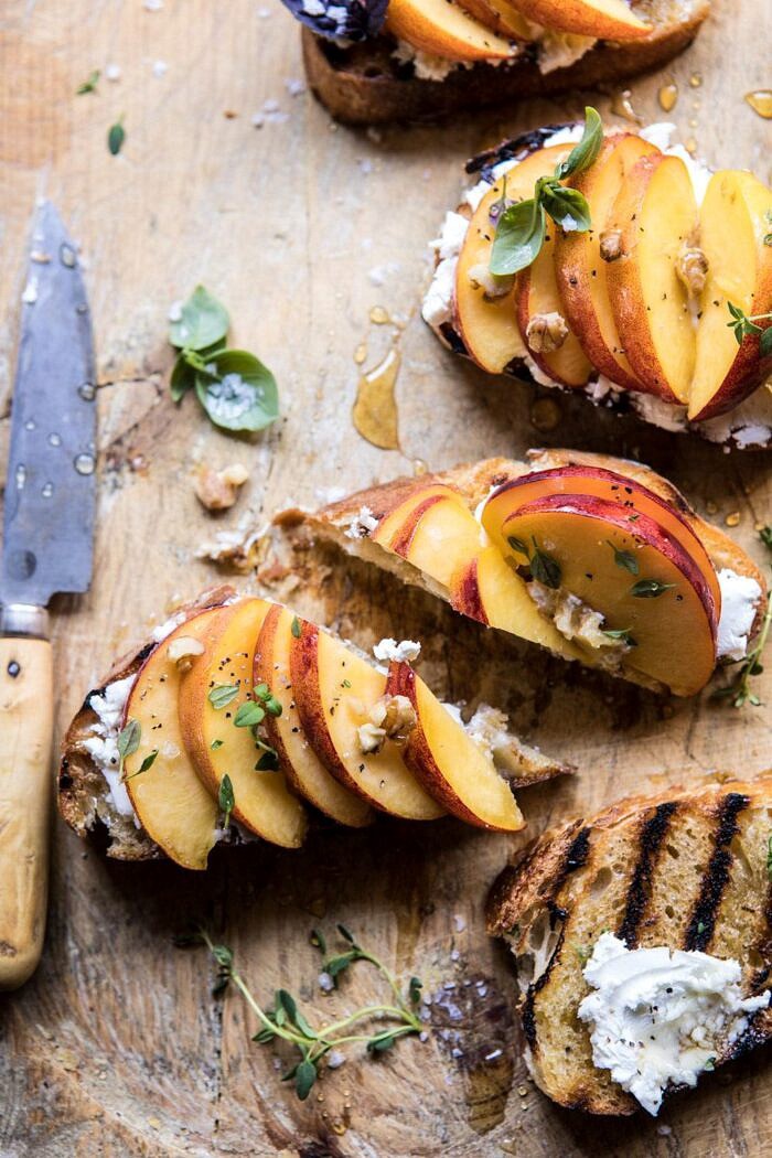 Thyme, Honey, Peach, and Goat Cheese Crostini | halfbakedharvest.com #peaches #summerrecipes #appetizers #easy overhead, close up photo Thyme, Honey, Peach, and Goat Cheese Crostini cut in half