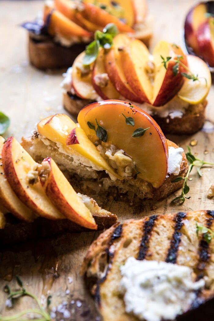 Thyme, Honey, Peach, and Goat Cheese Crostini | halfbakedharvest.com #peaches #summerrecipes #appetizers #easy side angle, close up photo Thyme, Honey, Peach, and Goat Cheese Crostini cut in half