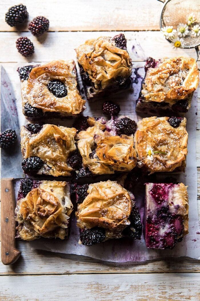 overhead photo of Blackberry Ruffled Milk Pie with flowers and knife in photo 