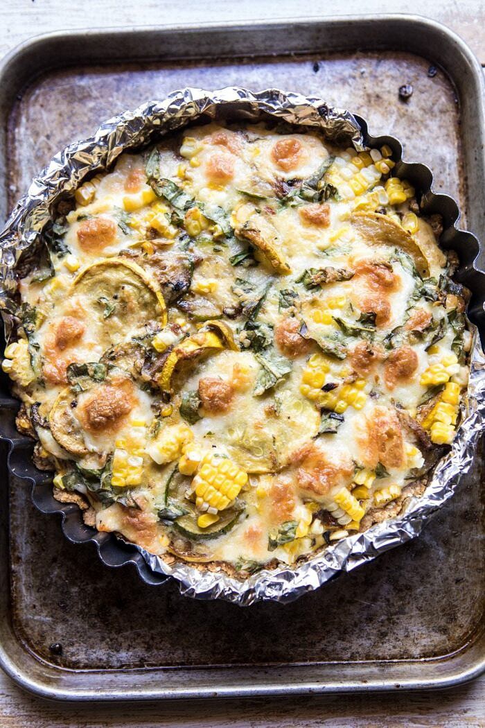 Cheesy Zucchini and Corn Pie | halfbakedharvest.com #zucchini #corn #summerrecipes #eggs #brie overhead photo Cheesy Zucchini and Corn Pie just out of the oven on sheet pan