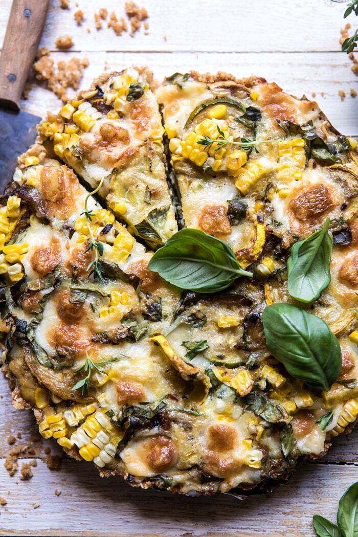 Cheesy Zucchini and Corn Pie | halfbakedharvest.com #zucchini #corn #summerrecipes #eggs #brie close up overhead photo of Cheesy Zucchini and Corn Pie with 1 piece cut and knife