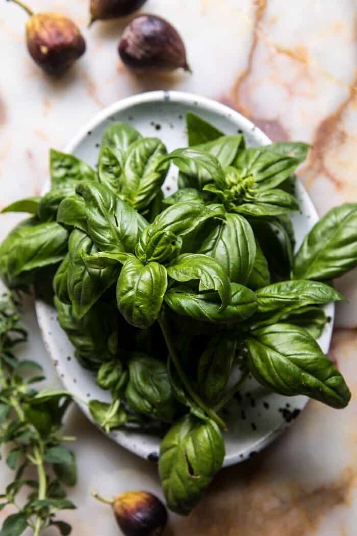 Fresh Fig, Prosciutto, and Arugula Salad with Cherry Tomato Vinaigrette | halfbakedharvest.com #summer #salad #tomatoes #burrata overhead photo of fresh basil and figs