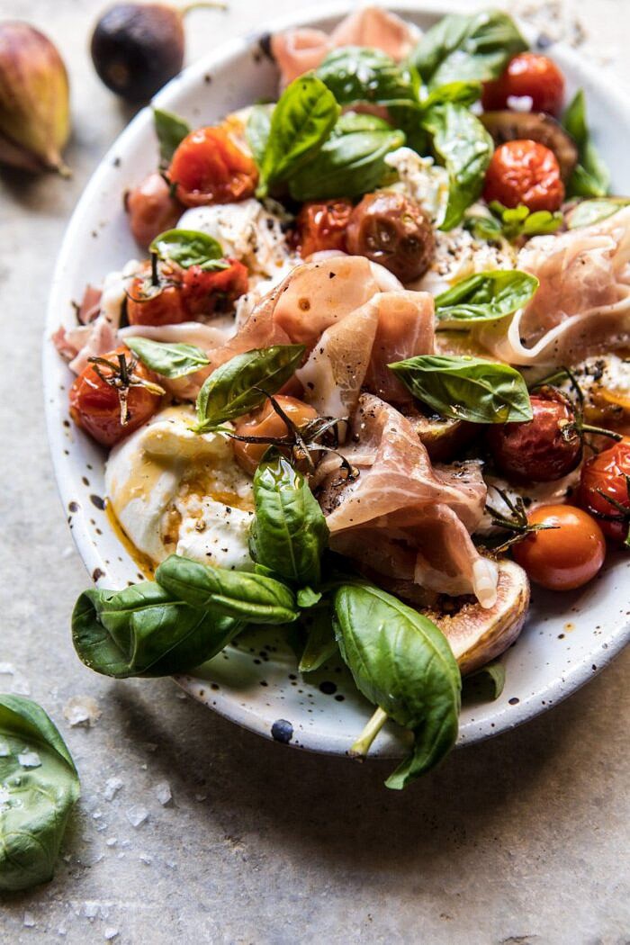 Fresh Fig, Prosciutto, and Arugula Salad with Cherry Tomato Vinaigrette | halfbakedharvest.com #summer #salad #tomatoes #burrata side angled photo of Fresh Fig, Prosciutto, and Arugula Salad with Cherry Tomato Vinaigrette