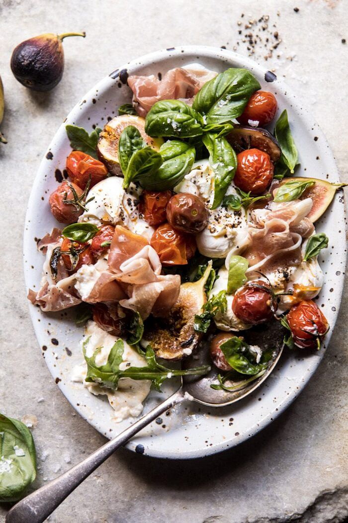 Fresh Fig, Prosciutto, and Arugula Salad with Cherry Tomato Vinaigrette | halfbakedharvest.com #summer #salad #tomatoes #burrata overhead photo of Fresh Fig, Prosciutto, and Arugula Salad with Cherry Tomato Vinaigrette and spoon in salad