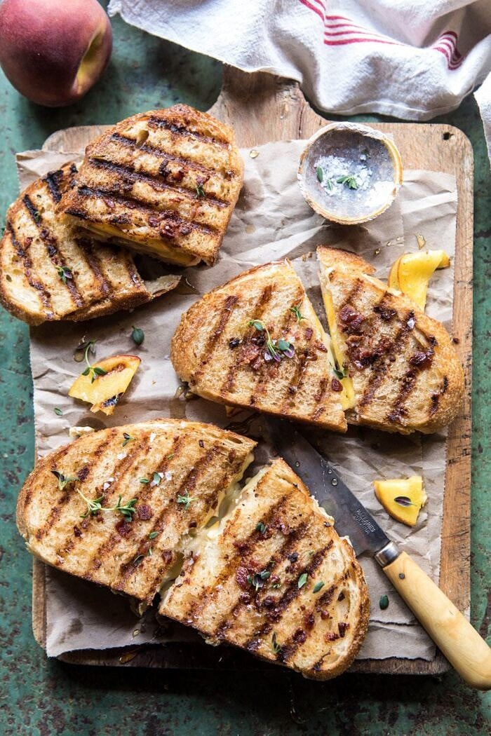 Honey, Peach, and Brie Panini with Bacon Butter | halfbakedhavrest.com #grilledcheese #peaches #easyrecipes #summer overhead photo of Honey, Peach, and Brie Panini with Bacon Butter with knife and salt