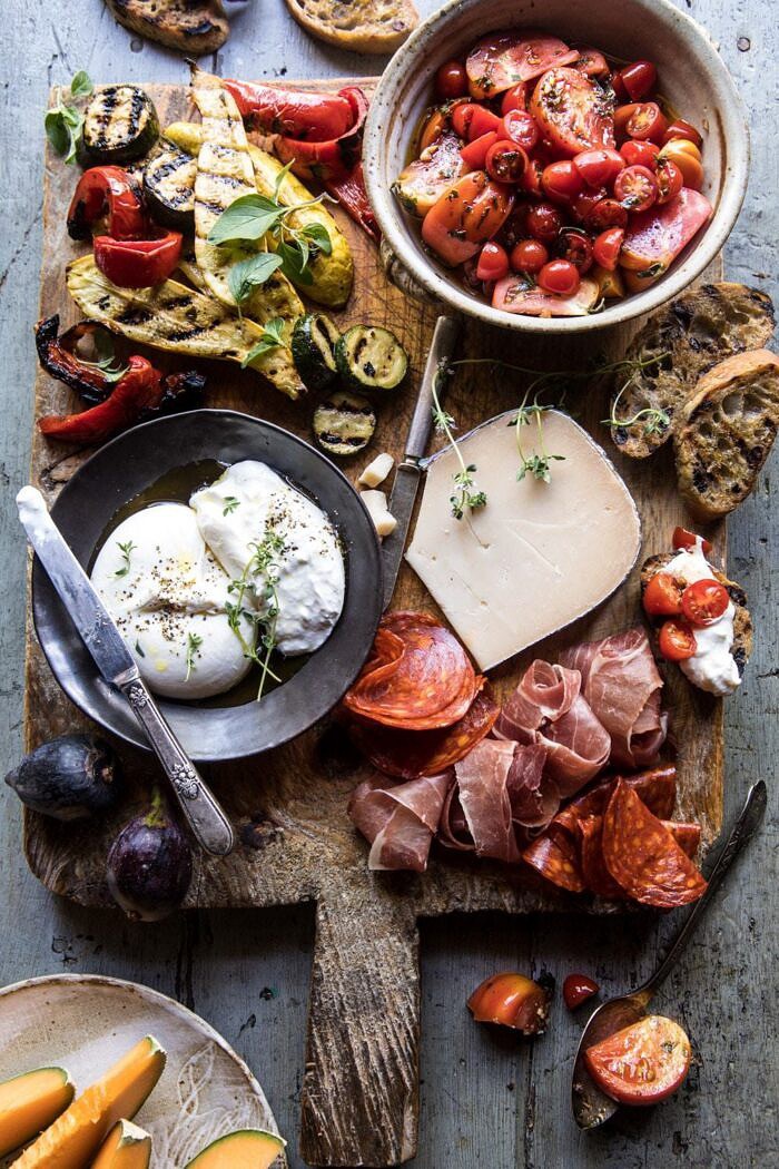 Marinated Tomato and Grilled Veggie Cheese Board | halfbakedharvest.com #cheeseboard #summerrecipes #easy #4thofjulyrecipe overhead photo of Marinated Tomato and Grilled Veggie Cheese Board with tomatoes on toast