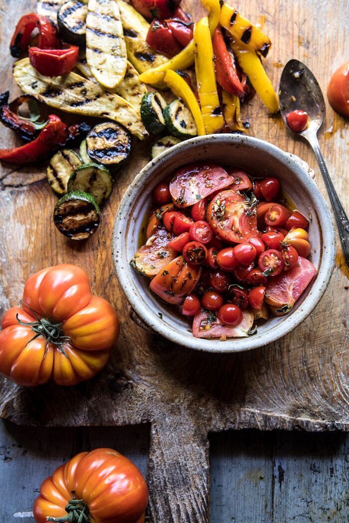 Marinated Tomato and Grilled Veggie Cheese Board | halfbakedharvest.com #cheeseboard #summerrecipes #easy #4thofjulyrecipe overhead photo of Marinated Tomatoes and Grilled Vegetables on cutting board