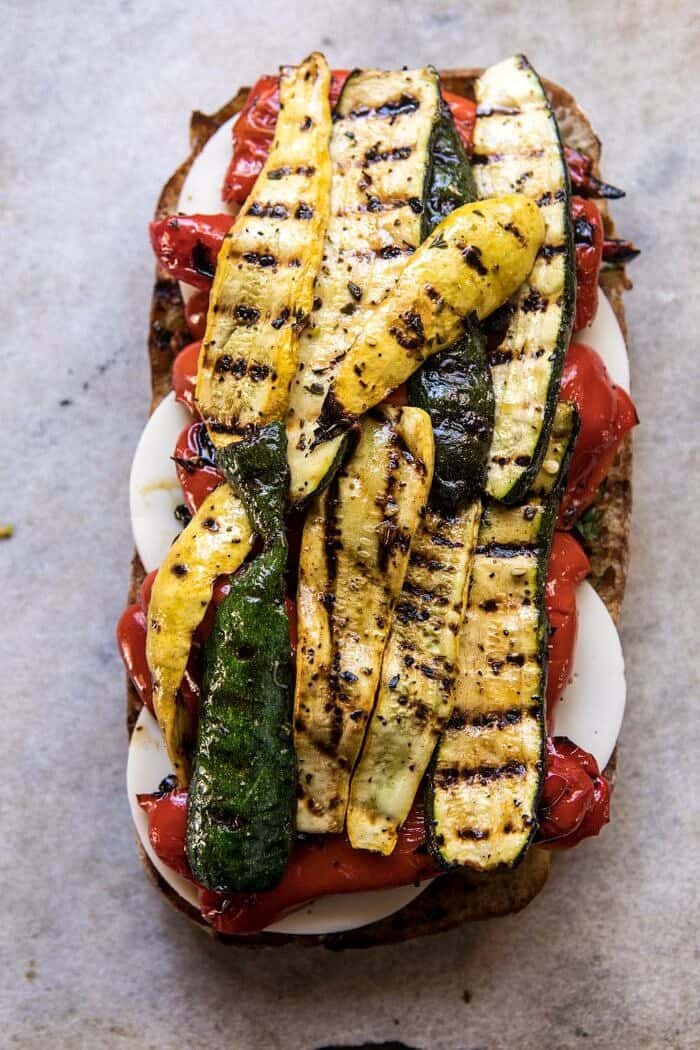 Marinated Veggie Cheese Sandwich with Sun-Dried Tomato Pesto | halfbakedharvest.com #easyrecipe #summer #sandwhich #healthyrecipes #dinner #easy #lunch overhead photo of Marinated Veggie Cheese Sandwich with Sun-Dried Tomato Pesto and grilled zucchini on top