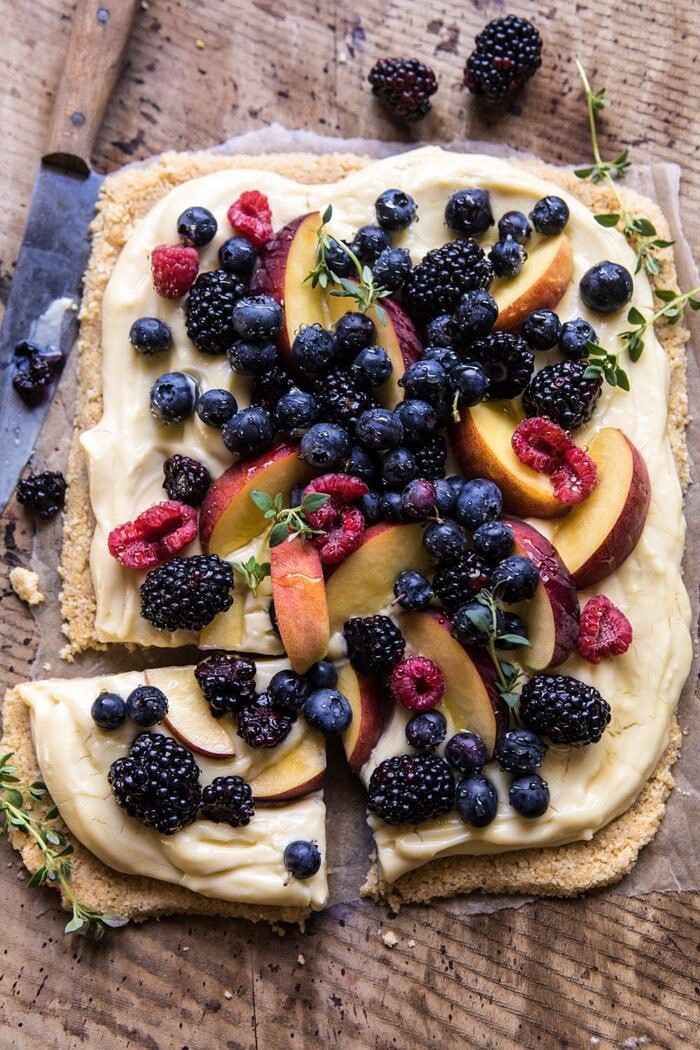 No Bake Mixed Berry Custard Tart | halfbakedharvest.com #summerrecipes #easyrecipes #nobake #fruit overhead photo of No Bake Mixed Berry Custard Tart with piece cut out an knife in photo