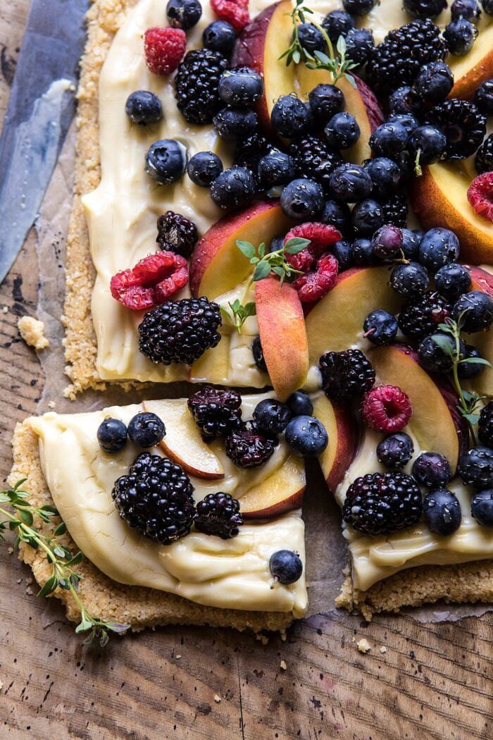 No Bake Mixed Berry Custard Tart | halfbakedharvest.com #summerrecipes #easyrecipes #nobake #fruit closer up overhead photo of No Bake Mixed Berry Custard Tart with piece cut out