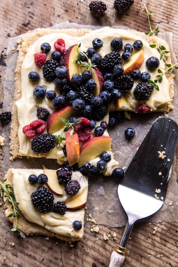No Bake Mixed Berry Custard Tart | halfbakedharvest.com #summerrecipes #easyrecipes #nobake #fruit overhead photo of No Bake Mixed Berry Custard Tart with pieces missing from tart