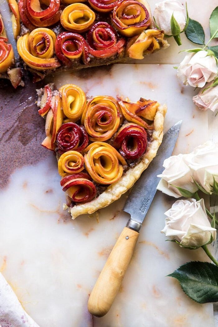 Sweet Peach Rose Tart | halfbakedharvest.com #peach #summerrecipes #tart #summer #pie overhead close up photo of Sweet Peach Rose Tart triangle with roses in photo