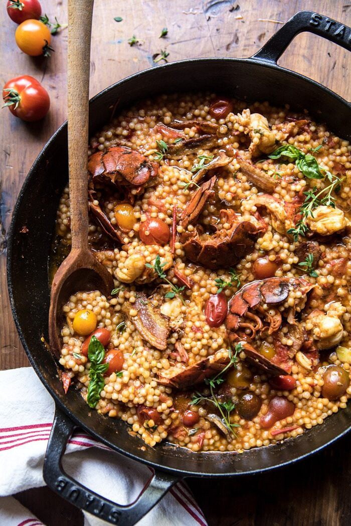 One Pot Tomato Basil Lobster and Herbed Pearl Couscous | halfbakedharvest.com #lobster #tomatoes #easyrecipes #summerrecipes #onepot overhead photo of One Pot Tomato Basil Lobster and Herbed Pearl Couscous with wooden spoon in pot