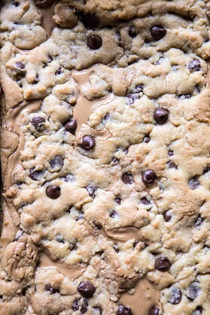 The Best Chocolate Chip Peanut Butter Swirled Cookie Bars | halfbakedharvest.com #cookies #cookiebars #peanutbutter #chocolate overhead photo of Chocolate Chip Peanut Butter Swirled Cookie Bars in baking pan fresh out of the oven