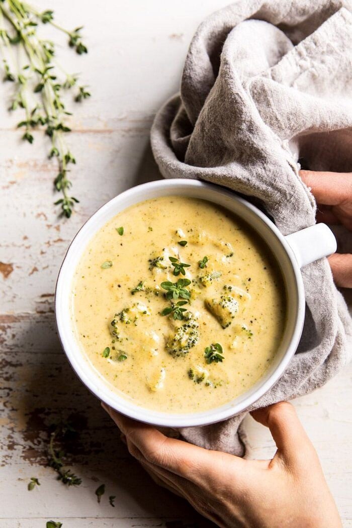 Instant Pot Broccoli Cheddar and Zucchini Soup | halfbakedharvest.com #instantpot #soup #broccoli #easy #healthy overhead photo of Instant Pot Broccoli Cheddar and Zucchini Soup with hands on bowl