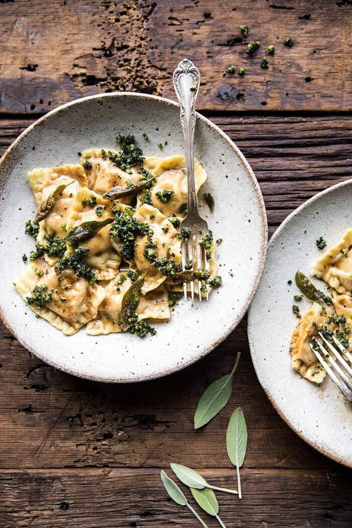 Butternut Squash Cheese Ravioli with Browned Butter Sage Pesto | halfbakedharvest.com #pasta #ravioli #fall #autumn #butternutsquash #fallrecipes overhead photo of Butternut Squash Cheese Ravioli with Browned Butter Sage Pesto with 2 bowls in photo