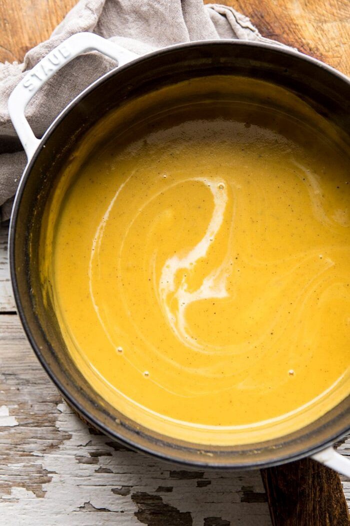 Cheddar Apple Butternut Squash Soup with Cinnamon Pecan Crumble | halfbakedharvest.com #soup #butternutsquash #autumnrecipes #thanksgiving overhead photo of Cheddar Apple Butternut Squash Soup in soup pot