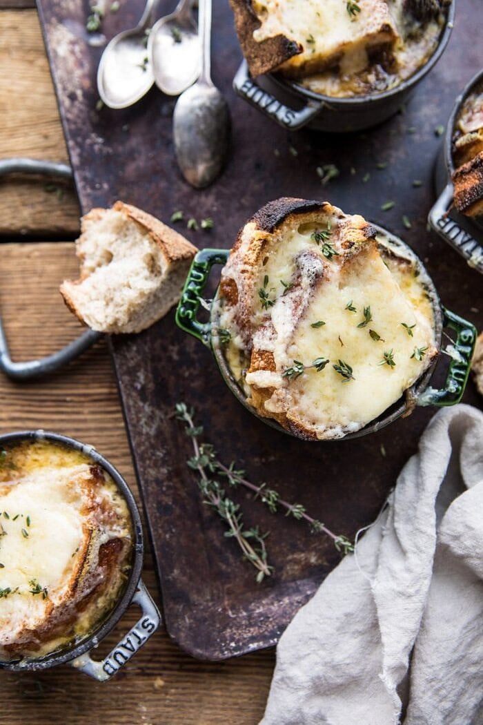 Herby French Shallot Soup | halfbakedharvest.com #french #soup #fallrecipes #cozyrecipes #familyrecipes overhead photo of Herby French Shallot Soup in soup bowls on trey with spoons and towel in photo