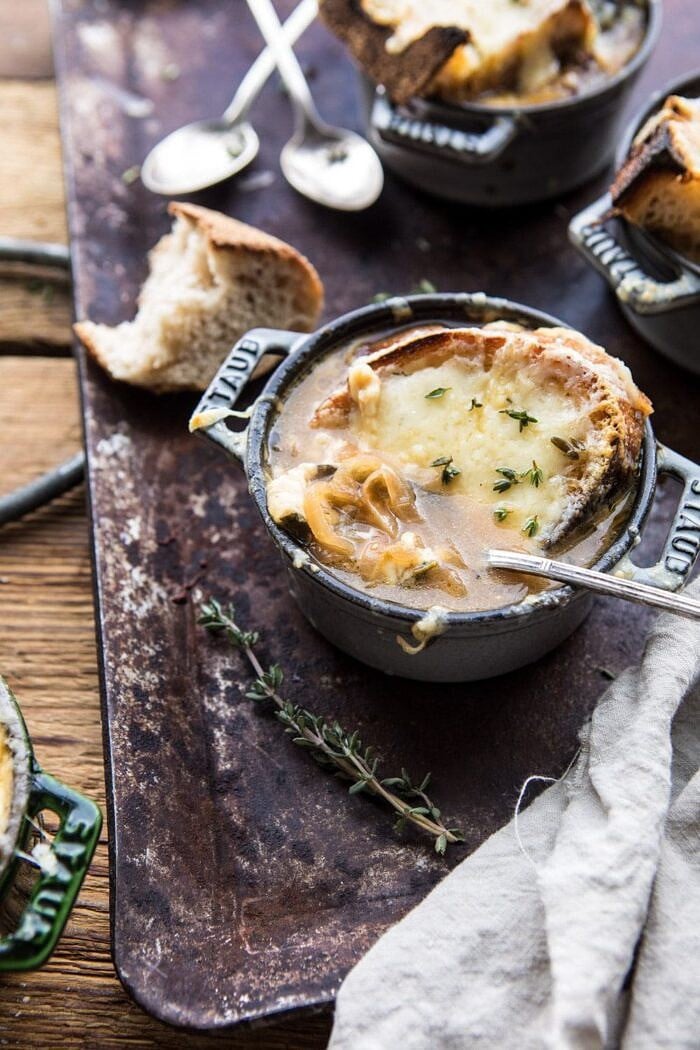 Herby French Shallot Soup | halfbakedharvest.com #french #soup #fallrecipes #cozyrecipes #familyrecipes side angled photo of Herby French Shallot Soup with spoon in bowl pulling up shallots