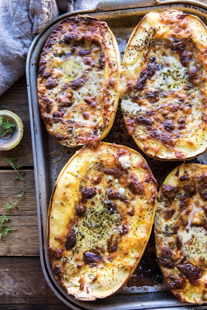 Stuffed Spaghetti Squash 4 Cheese Pesto Lasagna | halfbakedharvest.com #spaghettisquash #italian #easyrecipes #healthy #autumn #fallrecipes overhead photo of Stuffed Spaghetti Squash 4 Cheese Pesto Lasagna on baking sheet just as they have come out of the oven