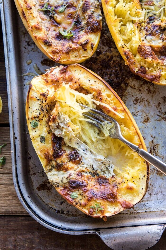 Stuffed Spaghetti Squash 4 Cheese Pesto Lasagna | halfbakedharvest.com #spaghettisquash #italian #easyrecipes #healthy #autumn #fallrecipes overhead, close up photo of Stuffed Spaghetti Squash 4 Cheese Pesto Lasagna with fork in spaghetti squash