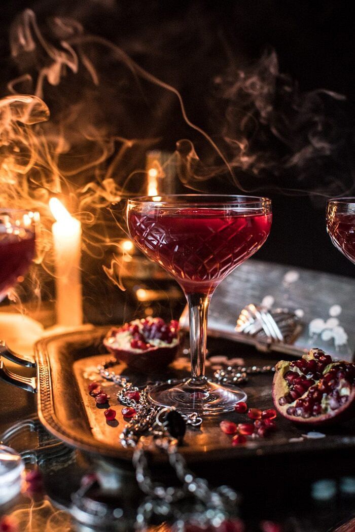 The Half Blood Prince Cocktail | halfbakedharvest.com #cocktails #halloween #pomegranate #fall #autumn front on photo of The Half Blood Prince Cocktail with smoke and candles in photo