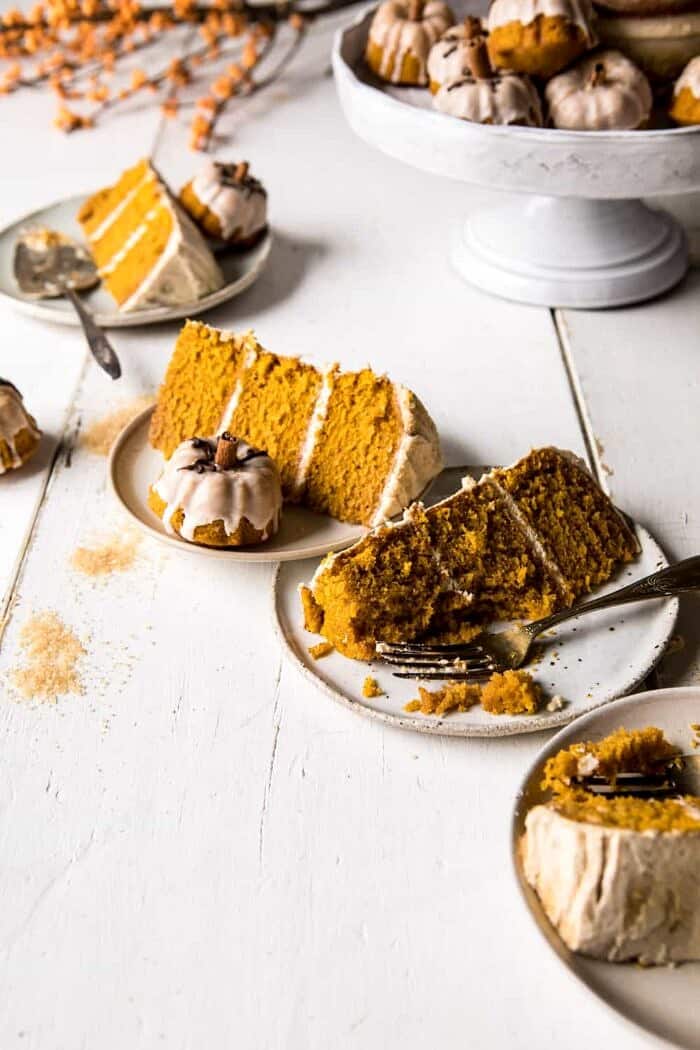 Chai Pumpkin Cake with Maple Browned Butter Frosting | halfbakedharvest.com #pumpkin #chai #fall #autumn #thanksgiving side angle photo of Chai Pumpkin Cake slices with cake stand in photo