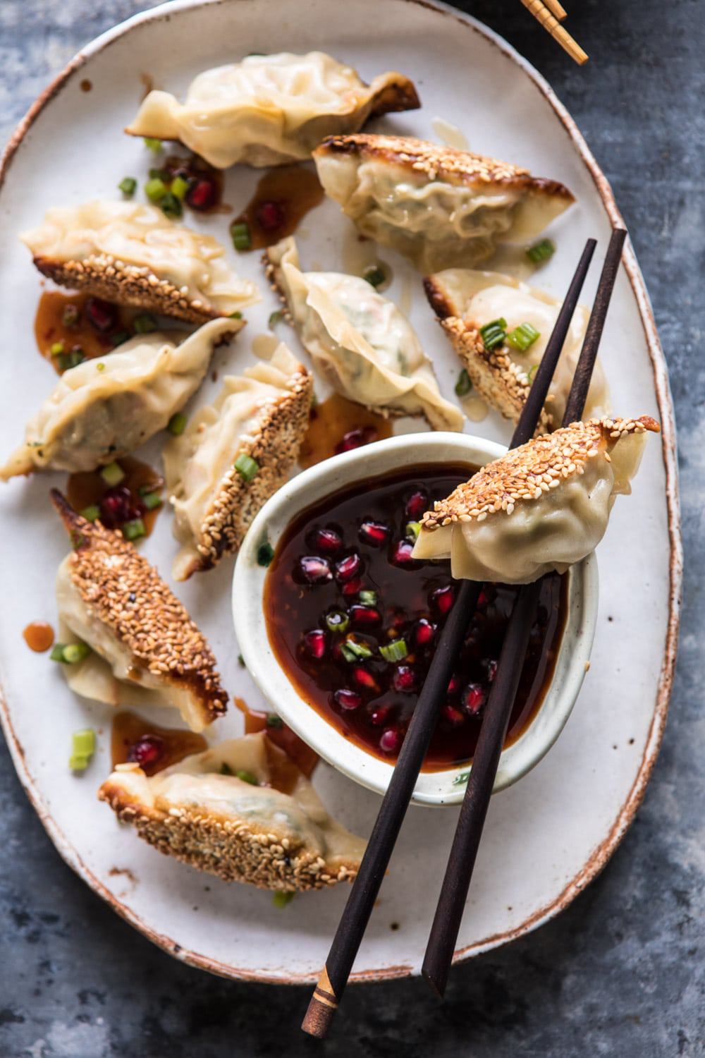 Ginger Sesame Chicken Potstickers with Sweet Chili Pomegranate Sauce | halfbakedharvest.com #asianrecipes #potstickers #dumplings #healthy