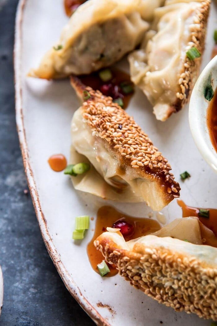 Ginger Sesame Chicken Potstickers with Sweet Chili Pomegranate Sauce | halfbakedharvest.com #asianrecipes #potstickers #dumplings #healthy close up photo of Ginger Sesame Chicken Potstickers with Sweet Chili Pomegranate Sauce