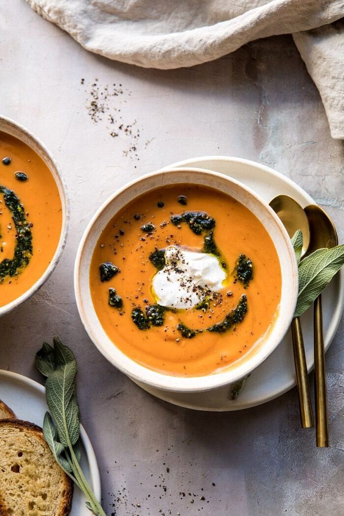 Golden Sweet Potato Soup with Burrata and Sage Pesto | halfbakedharvest.com #sweetpotato #soup #healthy #fall #autumn #winter #thanksgiving overhead photo of Golden Sweet Potato Soup with Burrata and Sage Pesto with towel and bread in photo