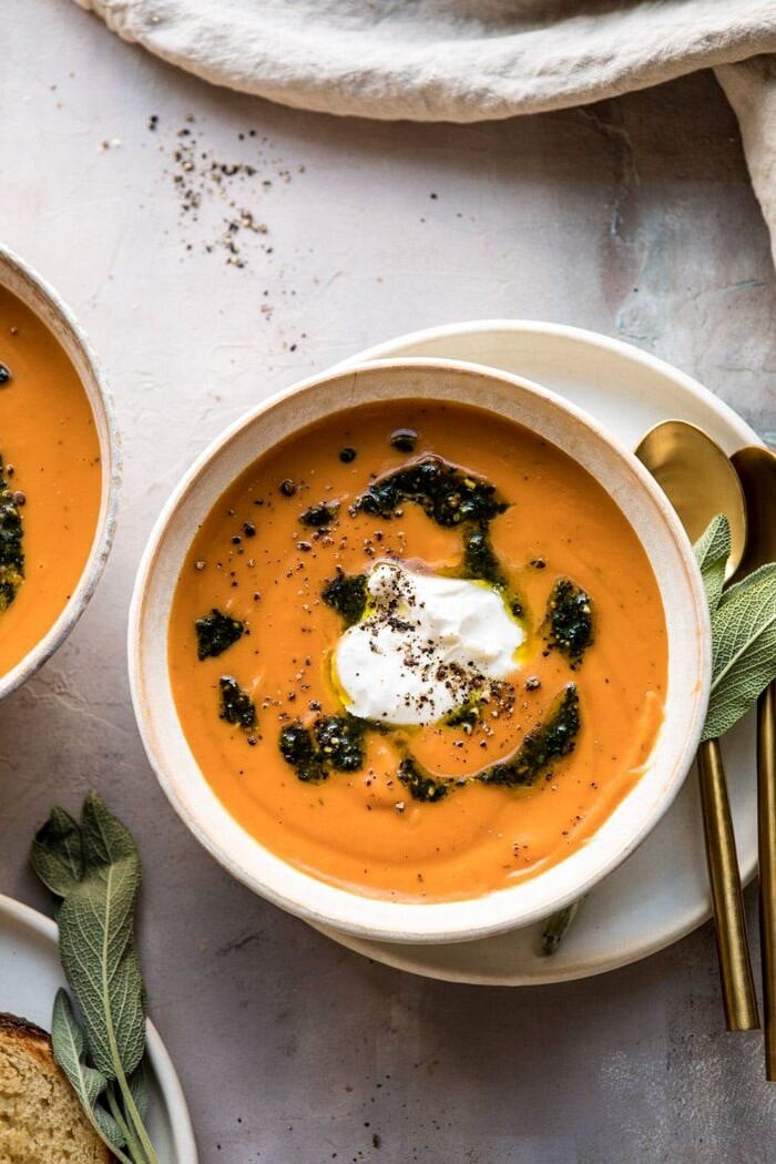 Golden Sweet Potato Soup with Burrata and Sage Pesto | halfbakedharvest.com #sweetpotato #soup #healthy #fall #autumn #winter #thanksgiving overhead close up photo of Sweet Potato Soup with Burrata and Sage Pesto with towel and bread in photo