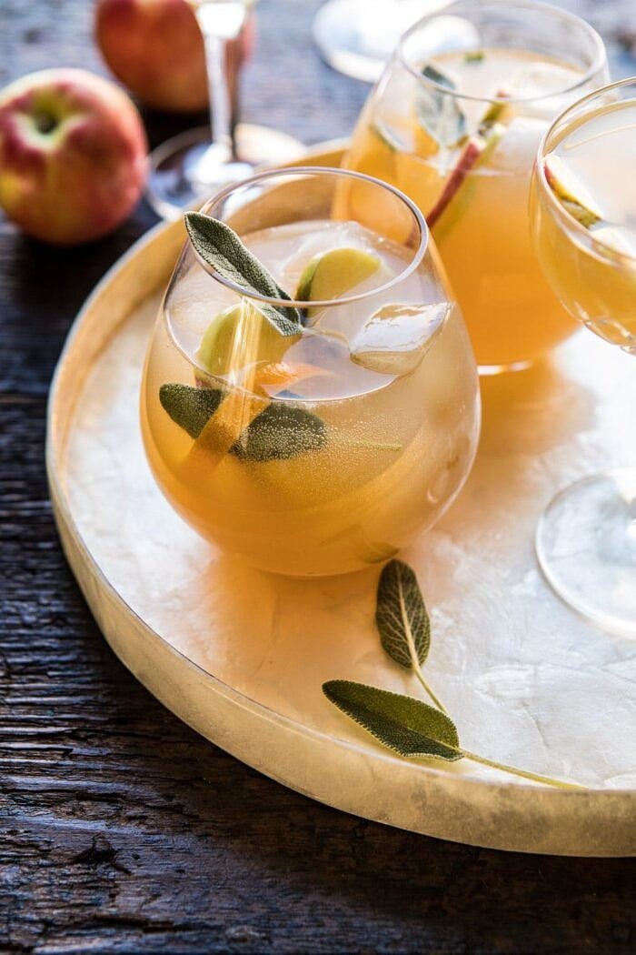 Harvest Apple Ginger Spritz | halfbakedharvest.com #fall #thanksgiving #apples #drinks #cocktails side angle photo Harvest Apple Ginger Spritz with apples and sage in photo