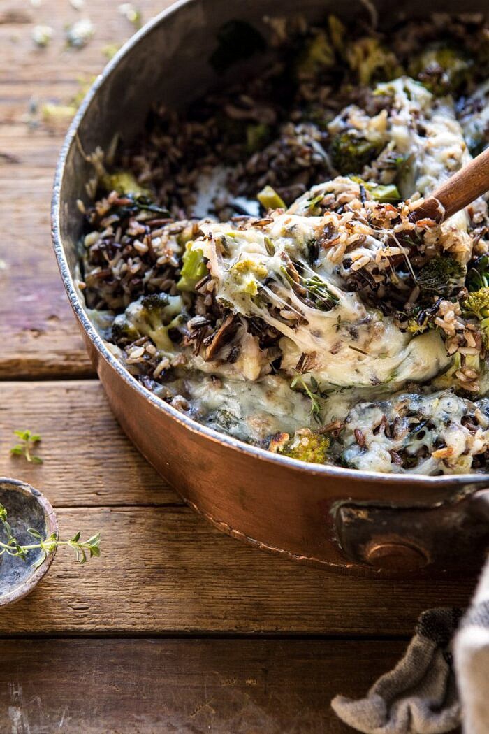 One Pan Broccoli Cheese Wild Rice Casserole | halfbakedharvest.com #wildrice #broccoli #casserole #fall #winter #easyrecipes #healthy side angle photo of One Pan Broccoli Cheese Wild Rice Casserole with spoon scooping rice out of pan