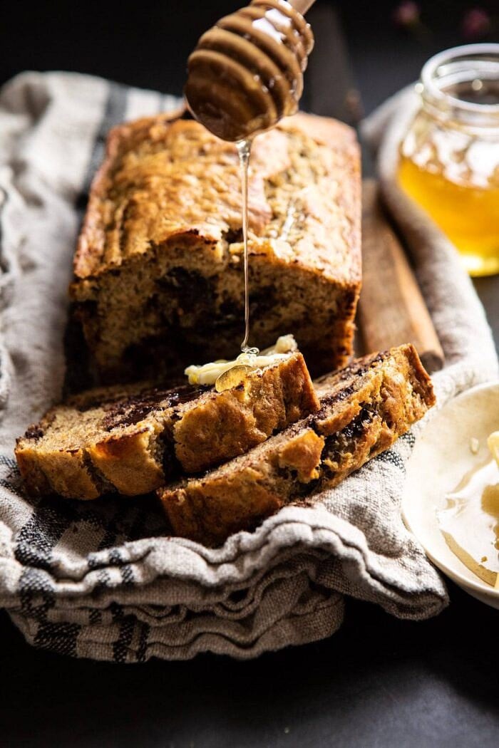 Chocolate Chunk Coconut Banana Bread | halfbakedharvest.com #bananabread #easyrecipes #healthyrecipes #chocolate #dessert Chocolate Chunk Coconut Banana Bread with honey being drizzle on