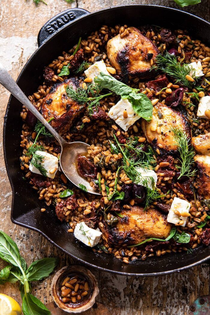 One Skillet Greek Sun-Dried Tomato Chicken and Farro | halfbakedharvest.com #skilletrecipes #chicken #healthyrecipes #onepan #easyrecipes overhead close up photo of One Skillet Greek Sun-Dried Tomato Chicken and Farro with spoon in skillet