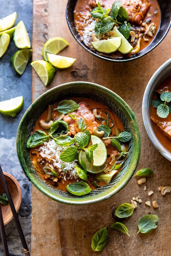 Saucy 30 Minute Thai Basil Salmon Curry | halfbakedharvest.com #healthyrecipes #salmon #curry #winterrecipes #thairecipes overhead photo of Saucy 30 Minute Thai Basil Salmon Curry with three bowls and limes