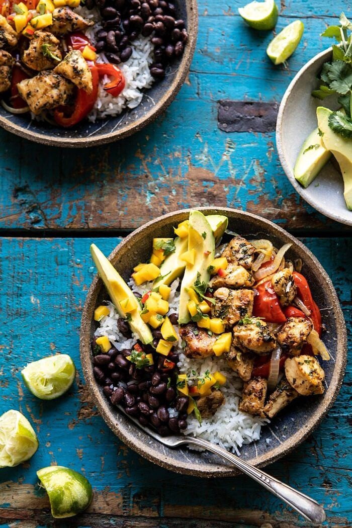 Sheet Pan Cuban Chicken and Black Bean Rice Bowl | halfbakedharvest.com #sheetpan #healthy #chicken #bowlrecipes #quick #easy overhead photo of Sheet Pan Cuban Chicken and Black Bean Rice Bowl and avocado and limes on surface
