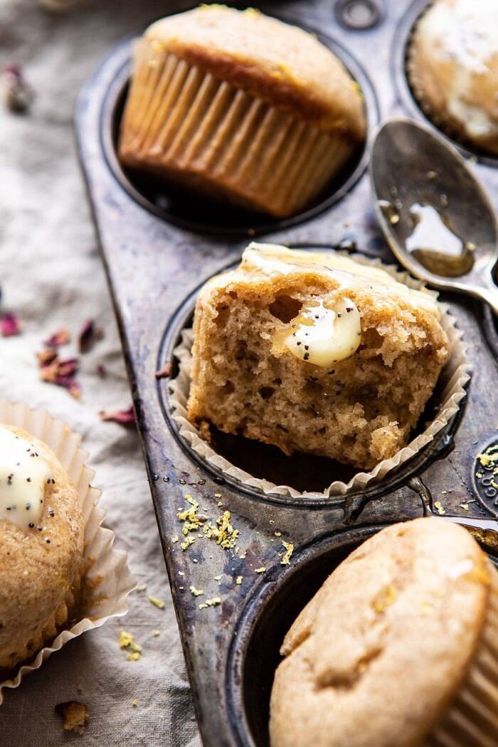 Vanilla Chai Lemon Ricotta Muffins | halfbakedharvest.com #breakfast #brunch #healthyrecipes #lemon #winter #chai side angle photo of Vanilla Chai Lemon Ricotta Muffins broken in half with butter on muffin