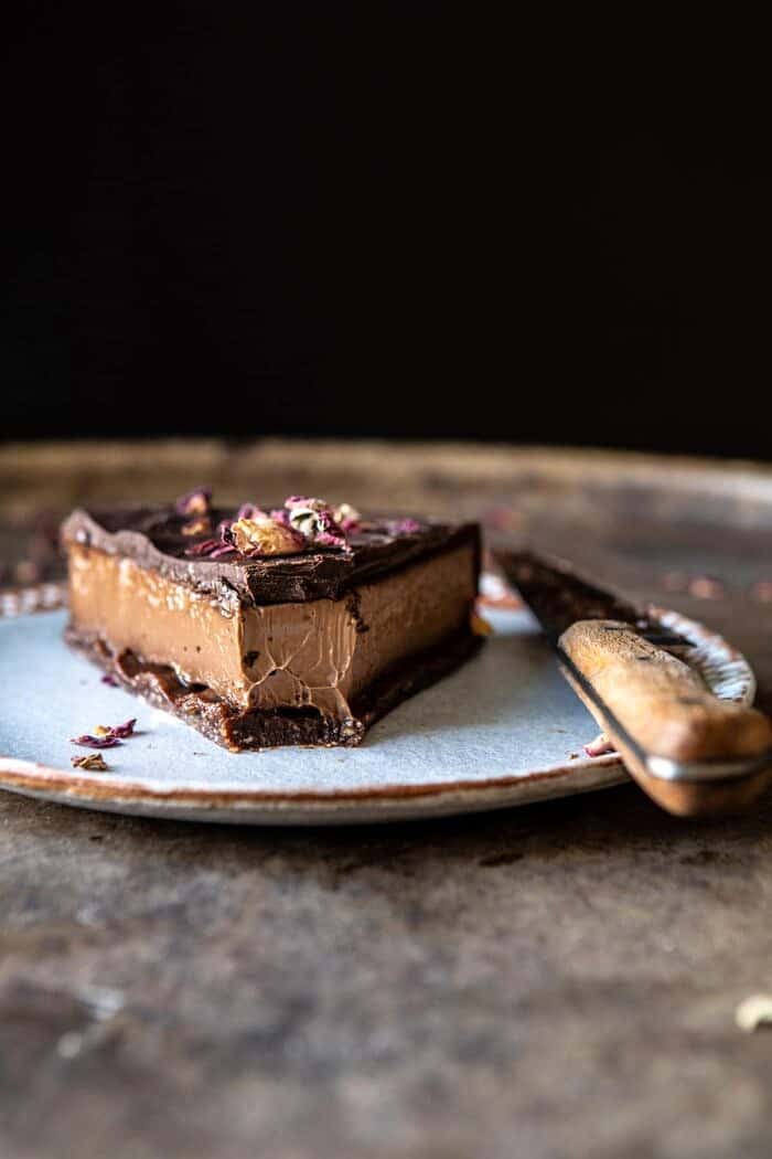 Vegan Triple Chocolate Mousse Cake | halfbakedharvest.com #chocolate #vegan #easyrecipes #dessert #cake #healthyrecipes side angle photo of Vegan Triple Chocolate Mousse Cake with bite taken out of cake piece