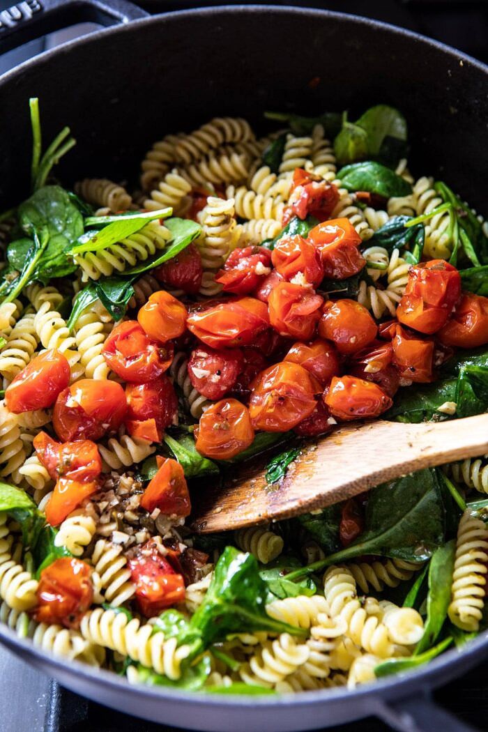 Caprese Pesto Pasta Bake | halfbakedharvest.com #caprese #pesto #pasta #easyrecipes Caprese Pesto Pasta being tossed together in bowl